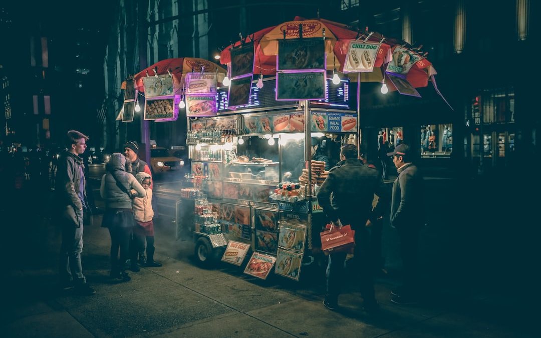 group of people standing near food cart