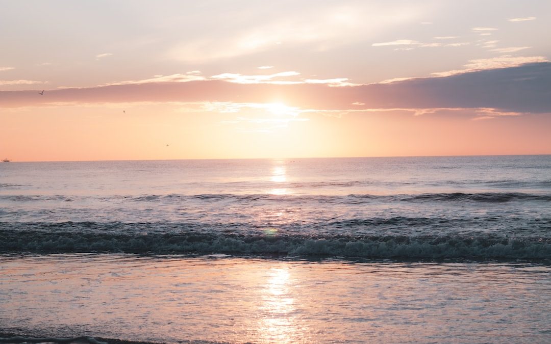 sea waves crashing on shore during sunset