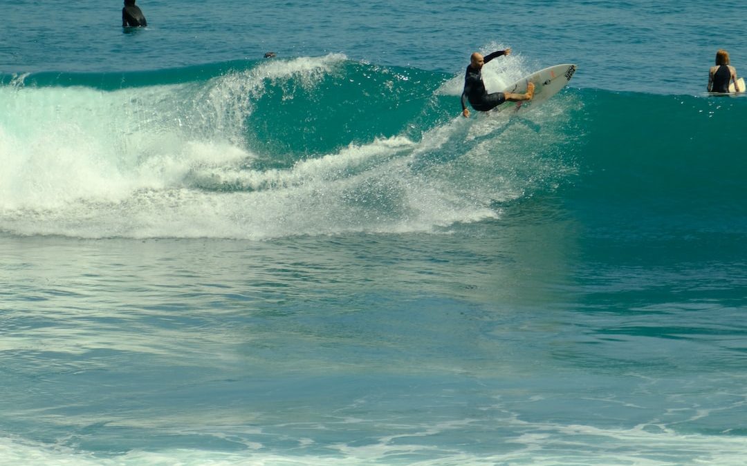 a man riding a wave on top of a surfboard