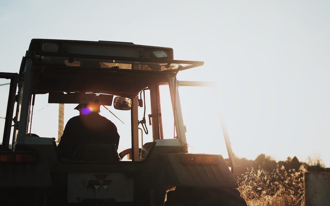 silhouette of man riding tractor