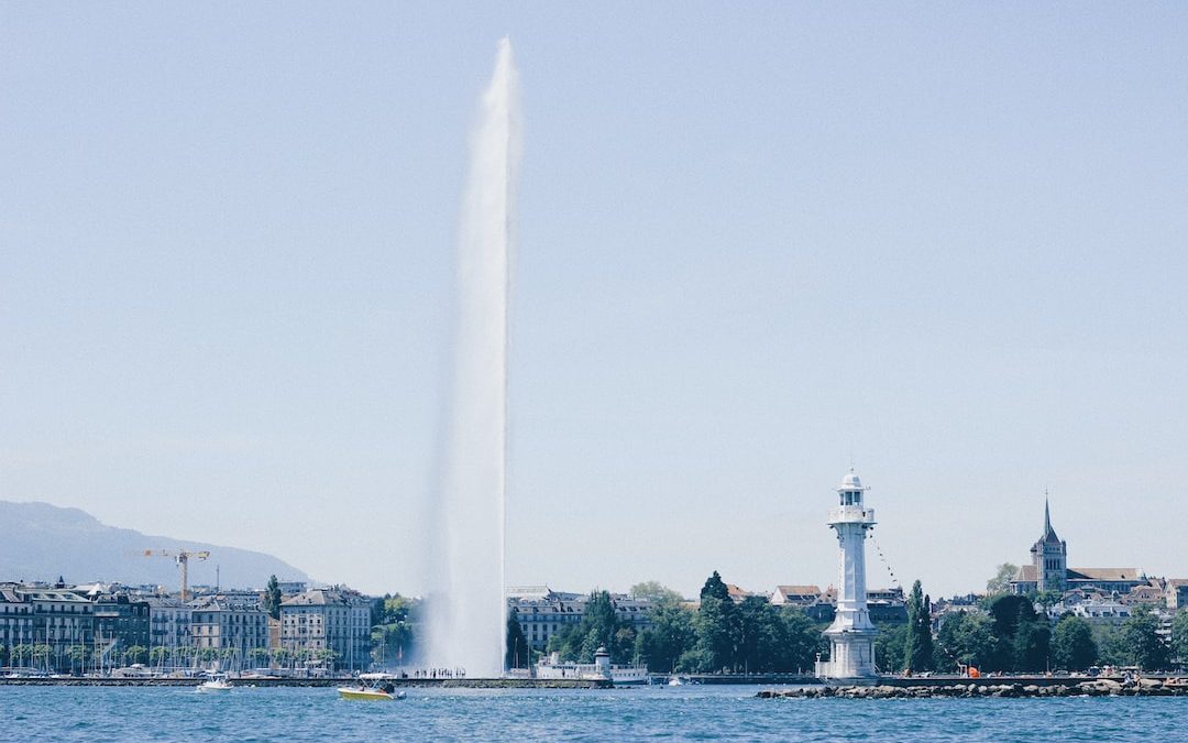 white lighthouse beside body of water during daytime