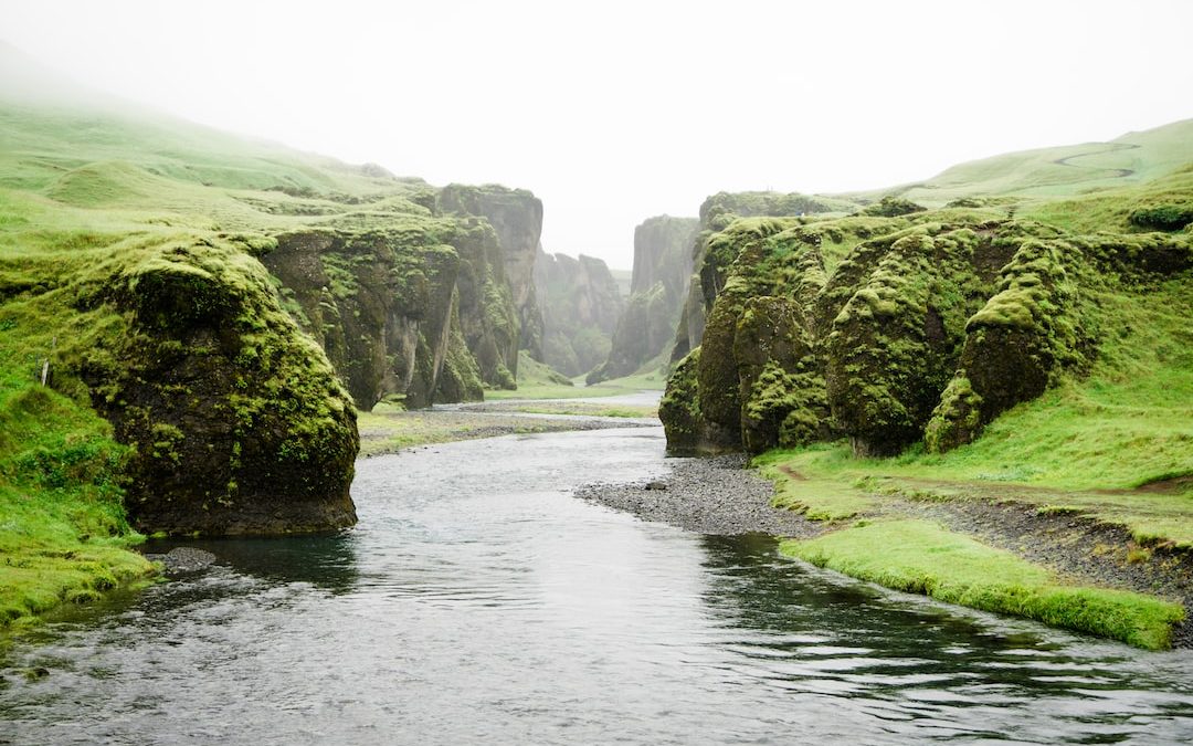 landscape photography of river between green mountains