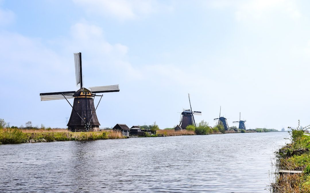 a body of water with windmills in the background