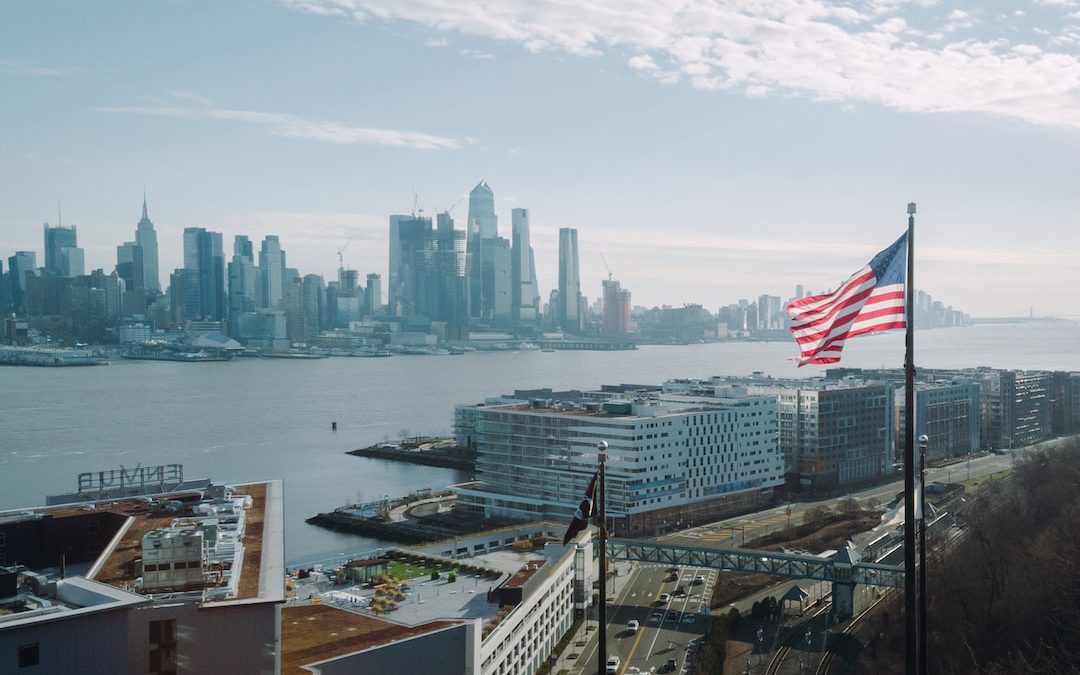 us a flag on top of building near body of water during daytime