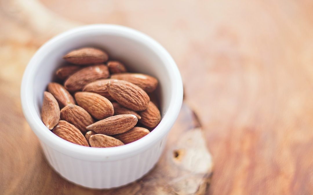 shallow focus photography of almonds in white ceramic bowl