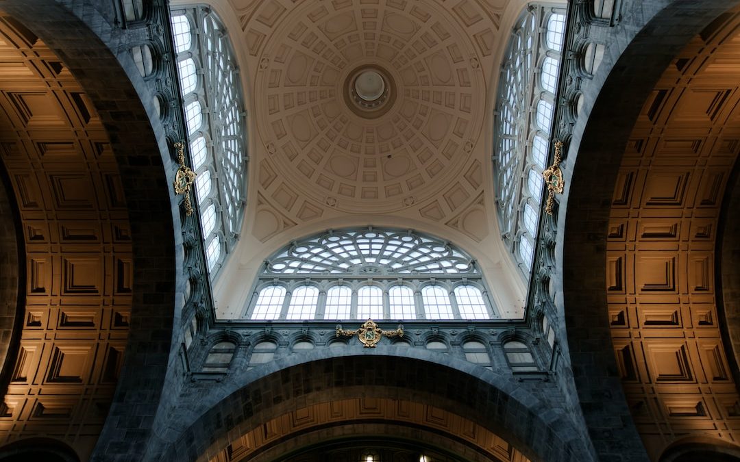 the ceiling of a large building with a clock on it