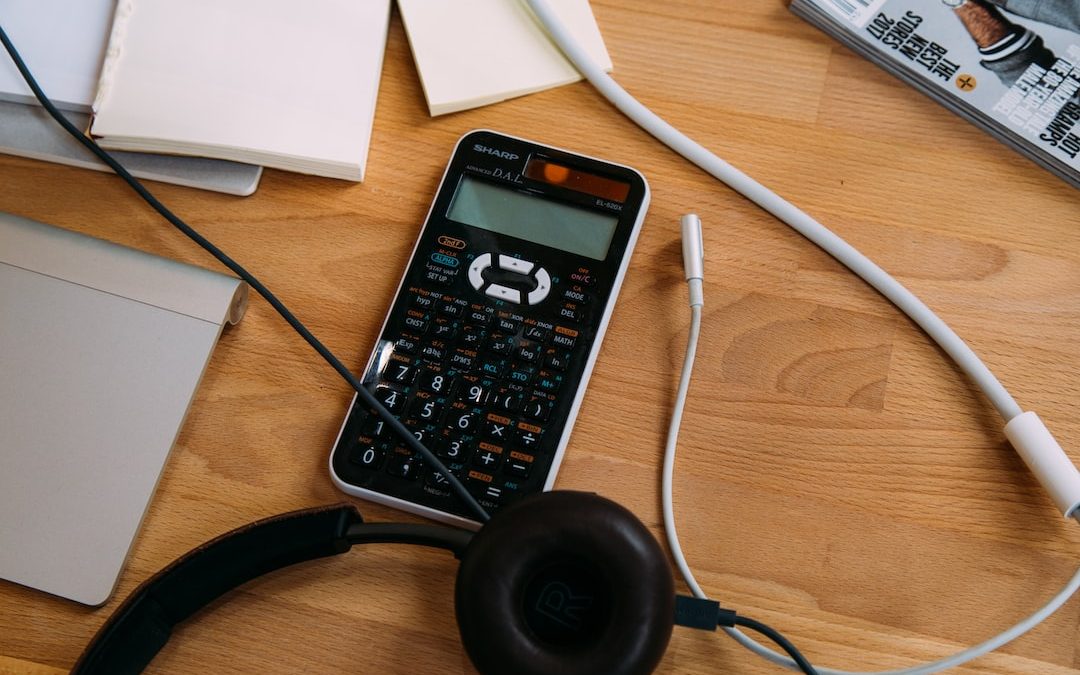 black scientific calculator beside black headphones