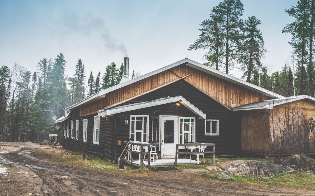 black and brown wooden house beside mud road