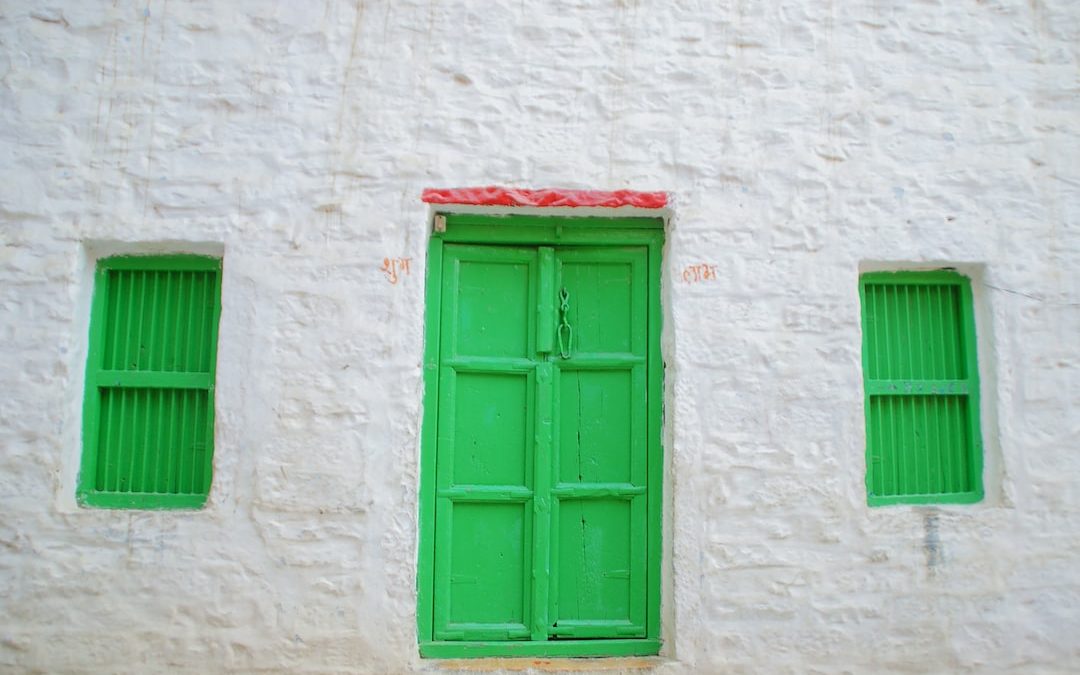 green wooden window on white concrete wall