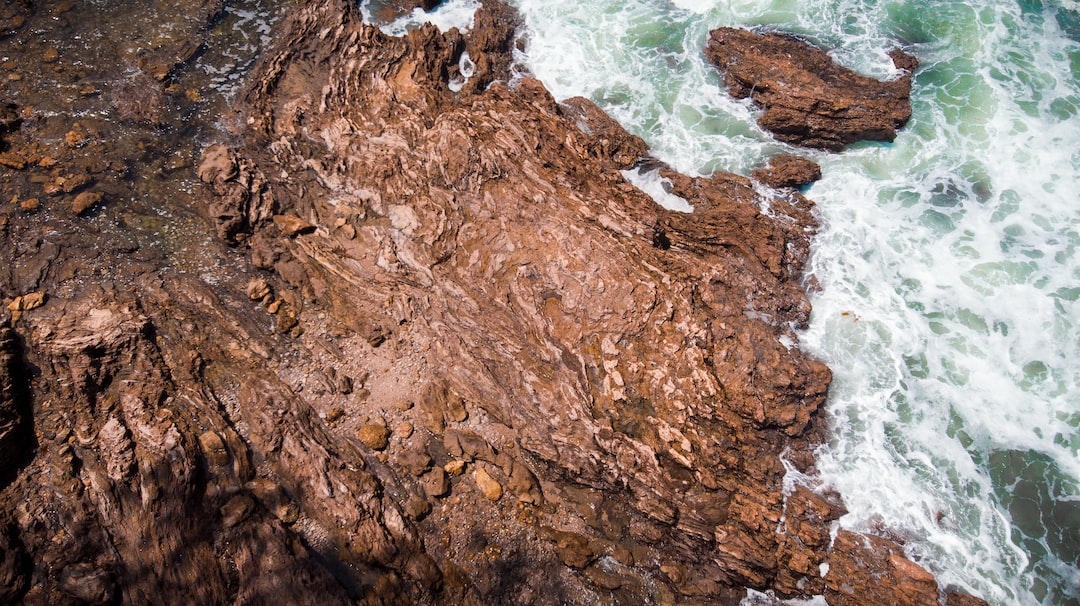 bird's-eye photography of rock fragment beside body of water