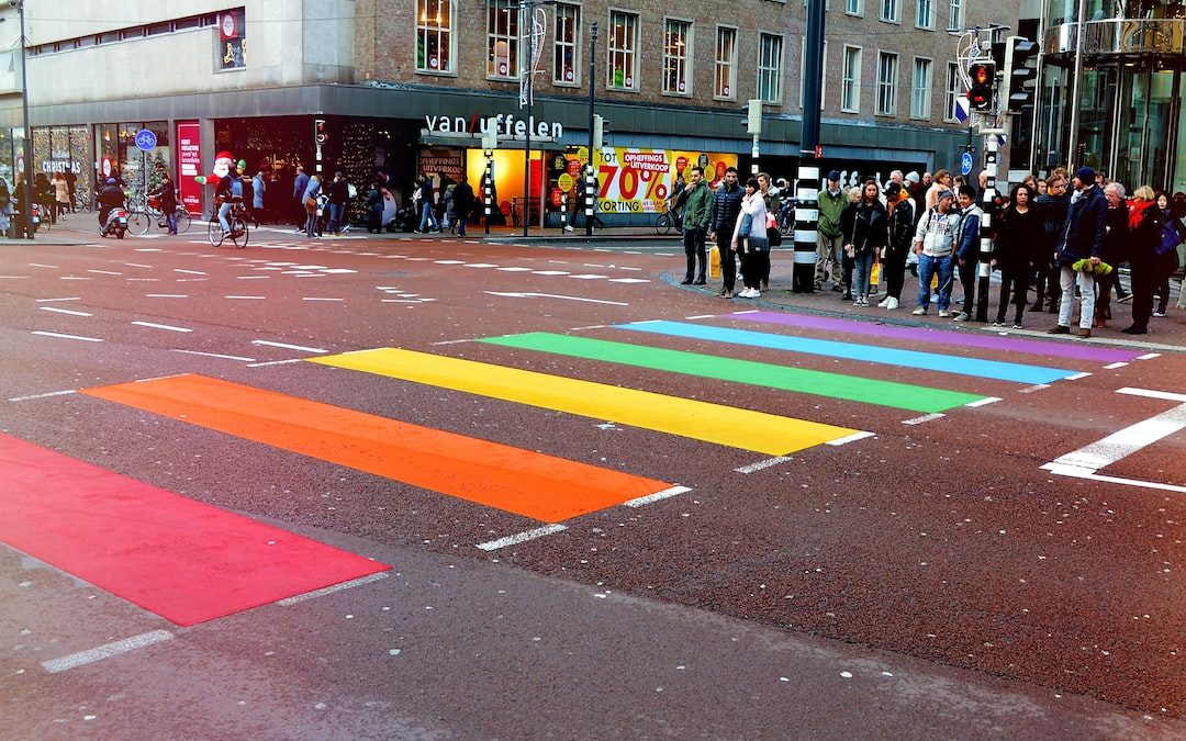 people standing on road in front of multicolored pedestrian line