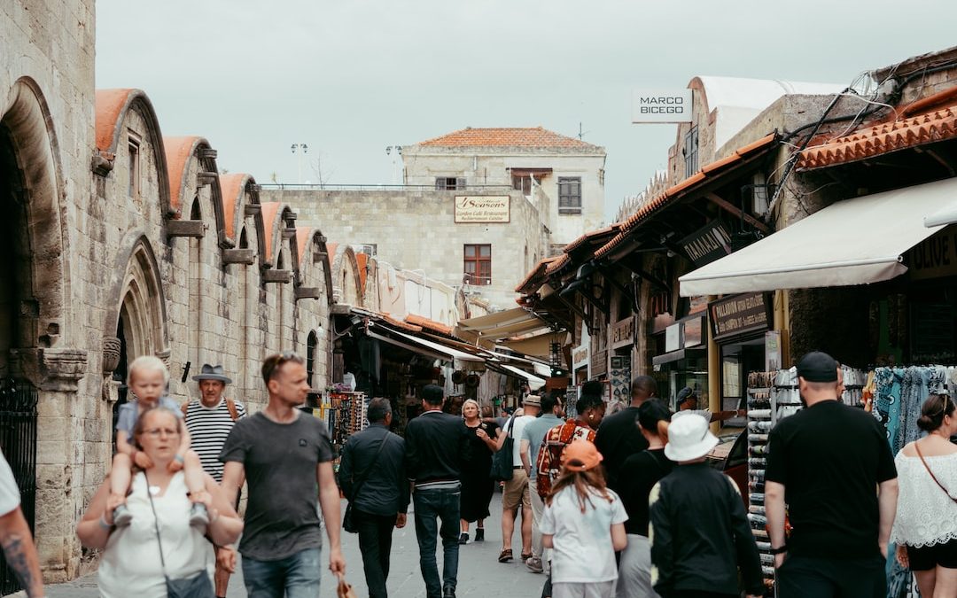 a group of people walking down a street next to buildings