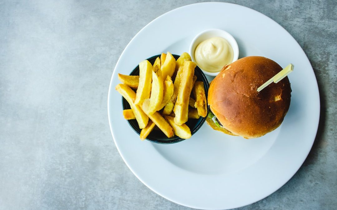 bowl of fries beside burger served on white plate