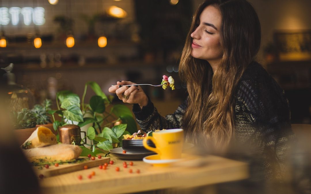 woman holding fork in front table