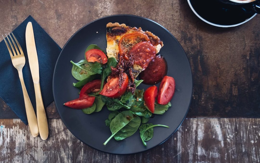 sliced tomato dish on black plate