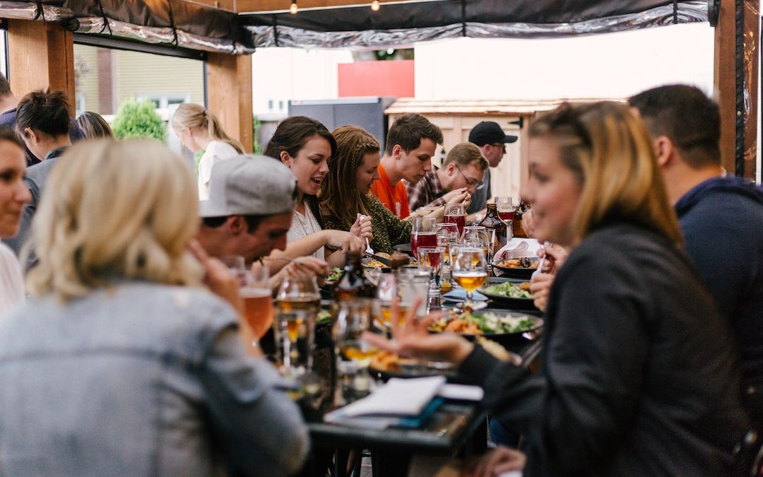 people sitting in front of table talking and eating