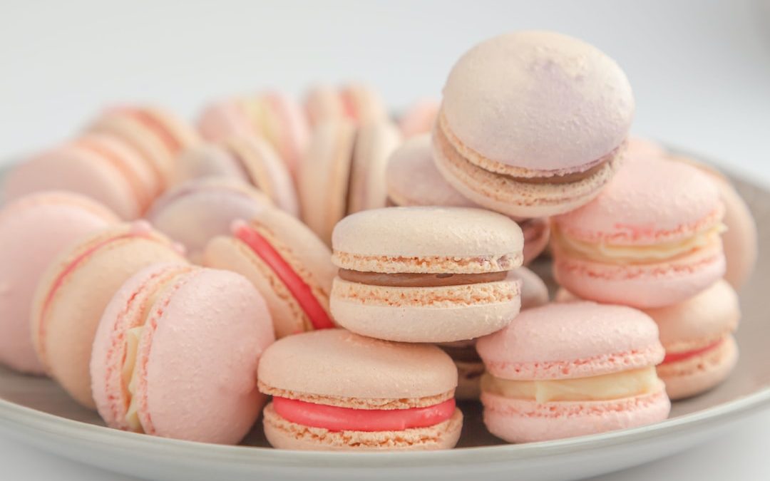 pink and white macaroons on white ceramic bowl