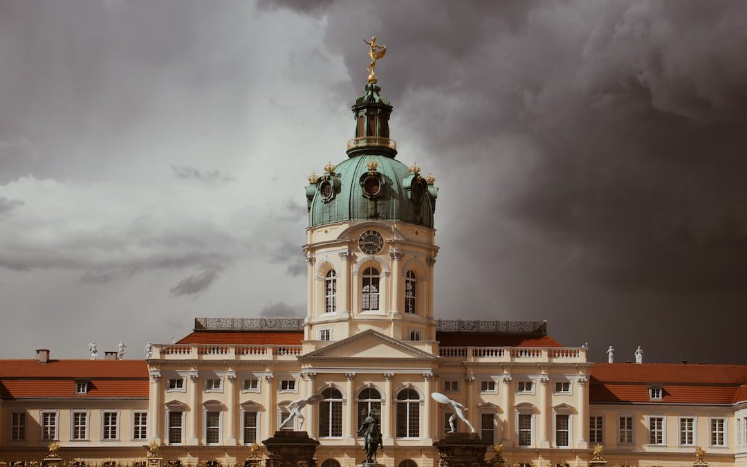 white and brown concrete building under gray clouds