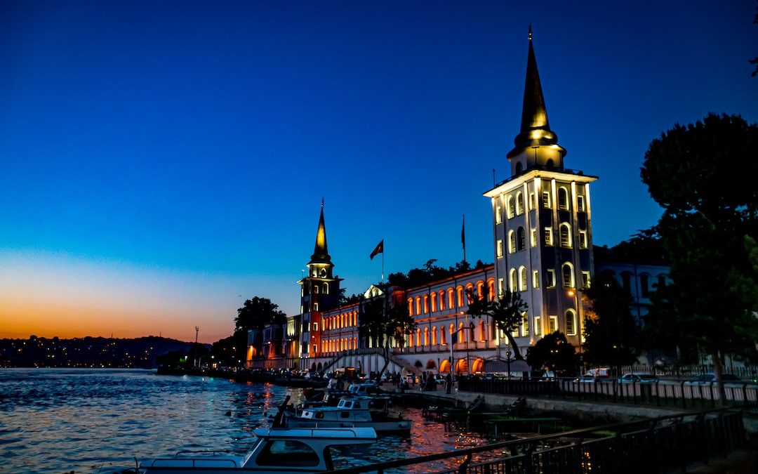 a building with a tower and boats in front of it