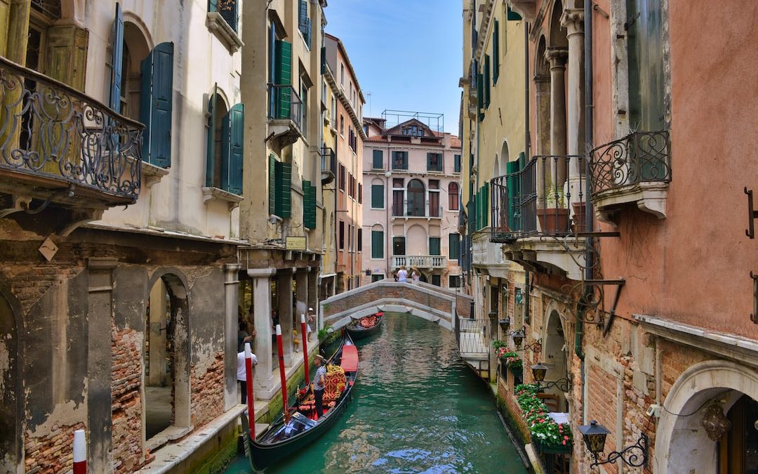 a boat on a canal between buildings