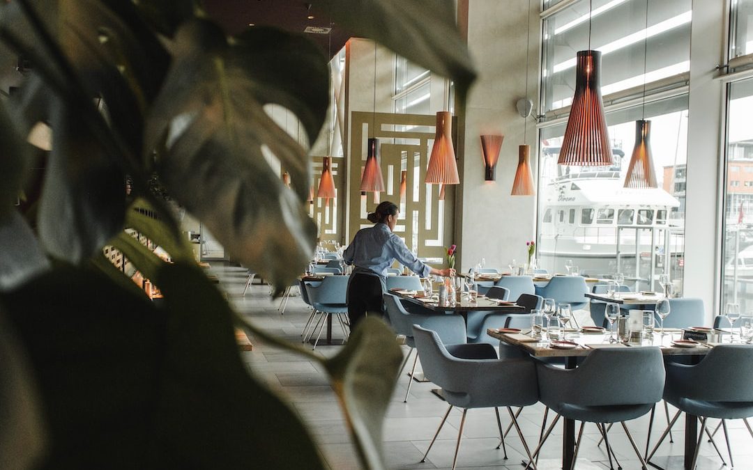 woman in front on brown dining table and chairs inside building