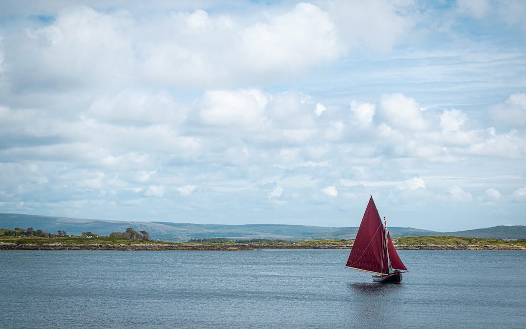 sailboat on sea under white clouds during daytime