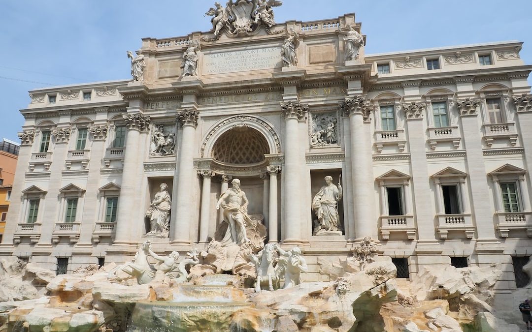 a large building with statues and a fountain in front of it with Trevi Fountain in the background