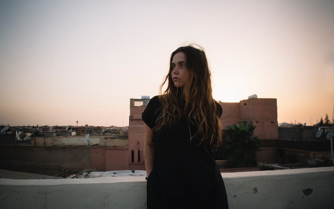 woman standing near white concrete wall during daytime