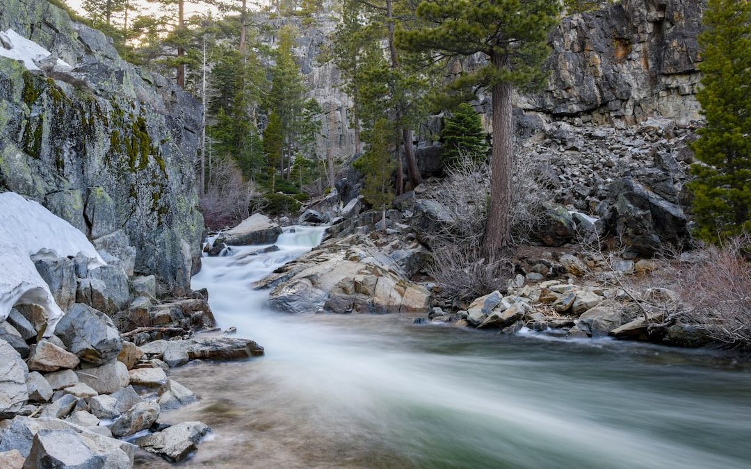 timelapse photography of river flowing between gray rock formations
