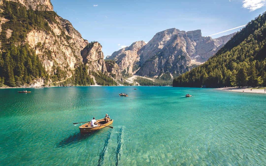 three brown wooden boat on blue lake water taken at daytime