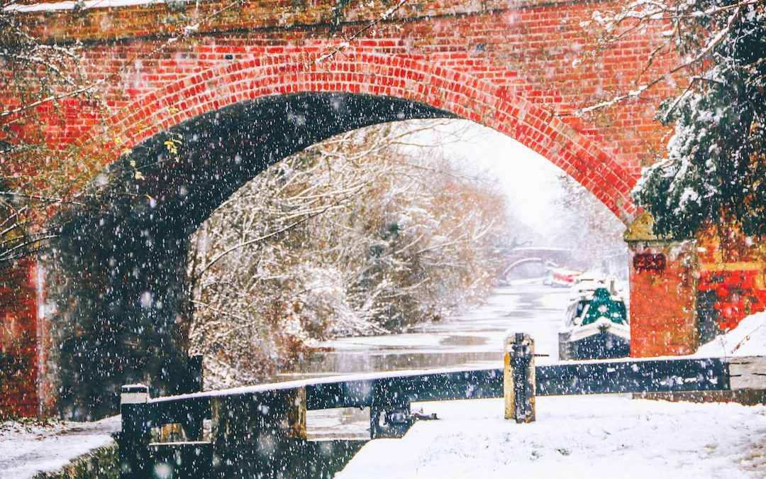 a bridge over a river with snow falling on it