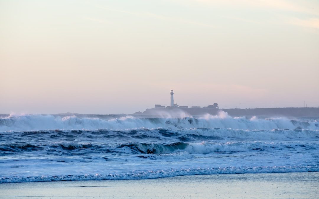lighthouse with seawaves during daytime