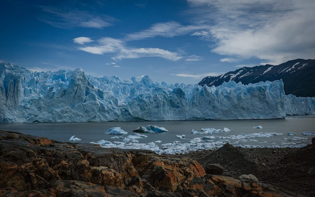 a body of water with ice and snow on the side with Perito Moreno Glacier in the background