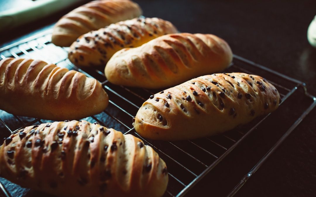 a bunch of loaves of bread sitting on a rack