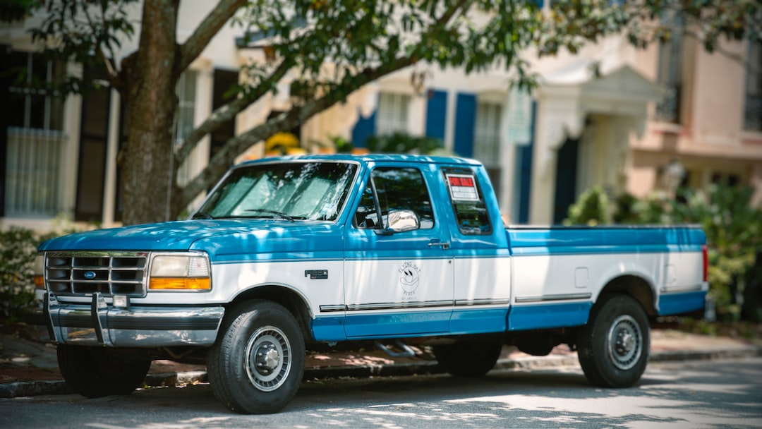 a blue truck parked on the side of the road