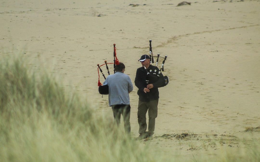 man in red shirt and gray pants holding black and brown rifle