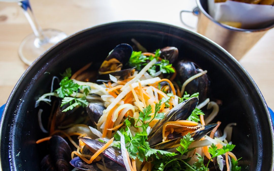 shallow focus photo of mussel dish on black pot