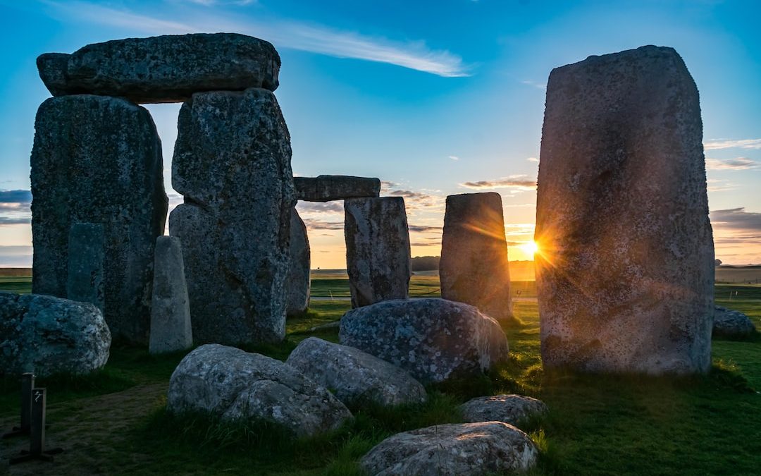 the sun is setting behind the stonehenge monument