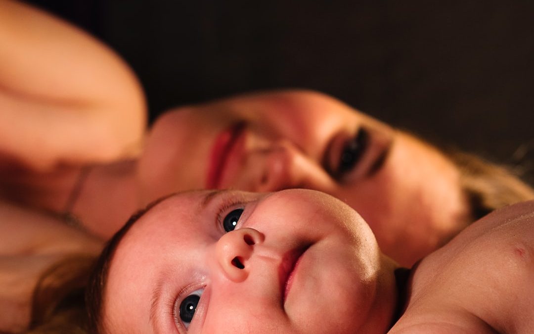 shallow focus photography of baby beside woman