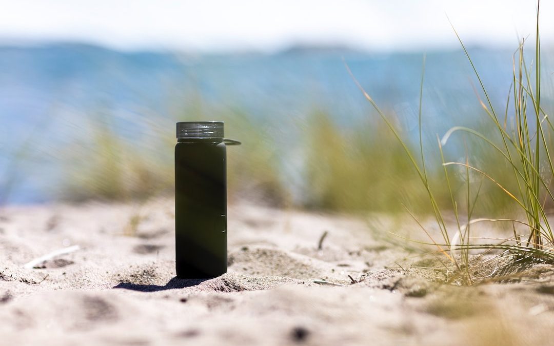 green and silver steel container on brown sand during daytime