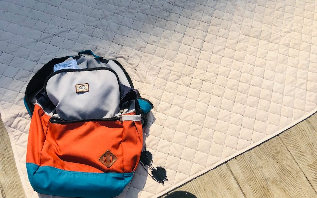 black and orange backpack on white floor