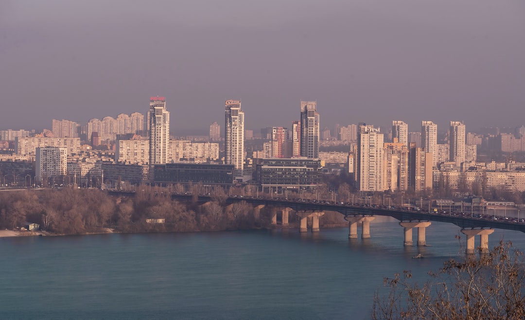 a bridge over a body of water with a city in the background