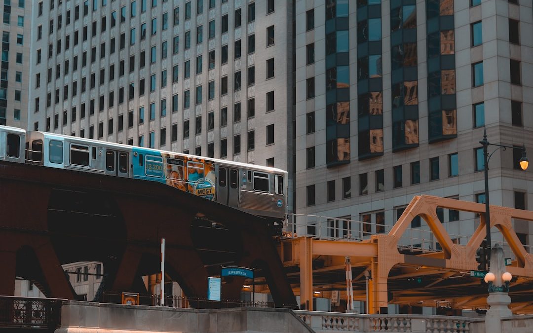 gray train in railway near high-rise building