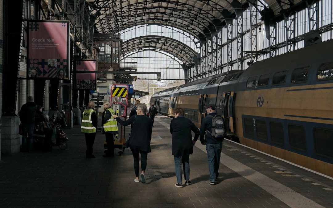 people walking on a platform next to a train