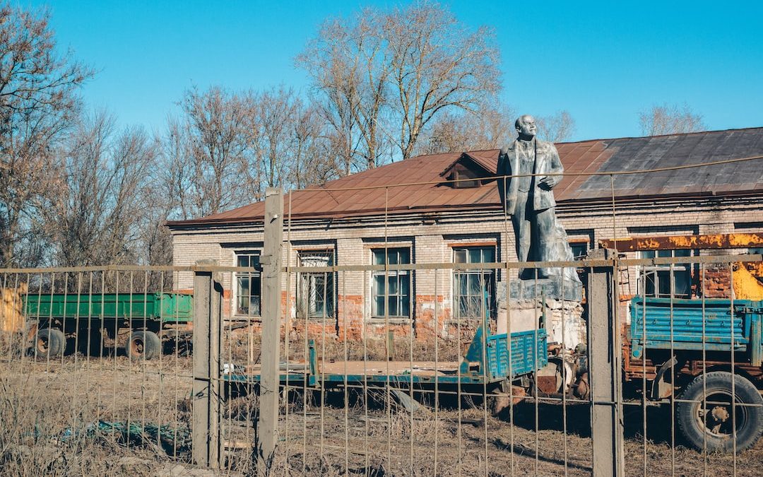 a statue of a person in a suit standing on a fence