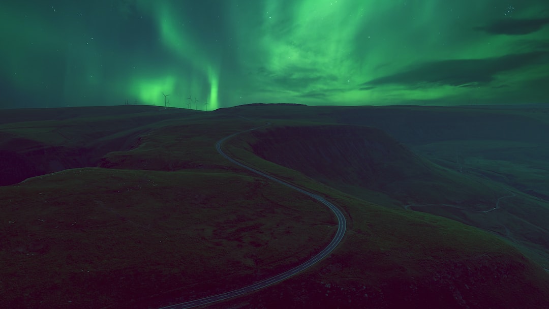 a green and purple aurora borealis over a mountain range