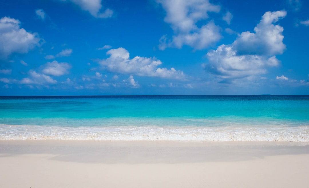 blue sea under blue sky and white clouds during daytime