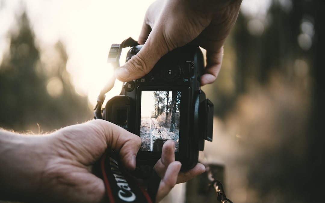 person holding Canon DSLR camera