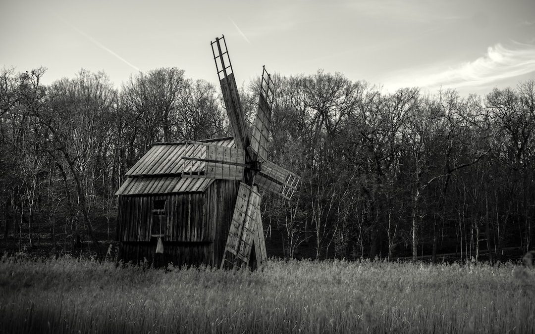 a black and white photo of a windmill in a field