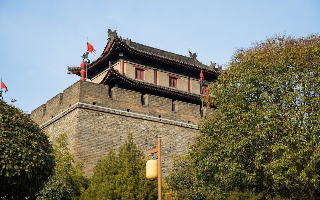 a tall brick building with red flags on top of it